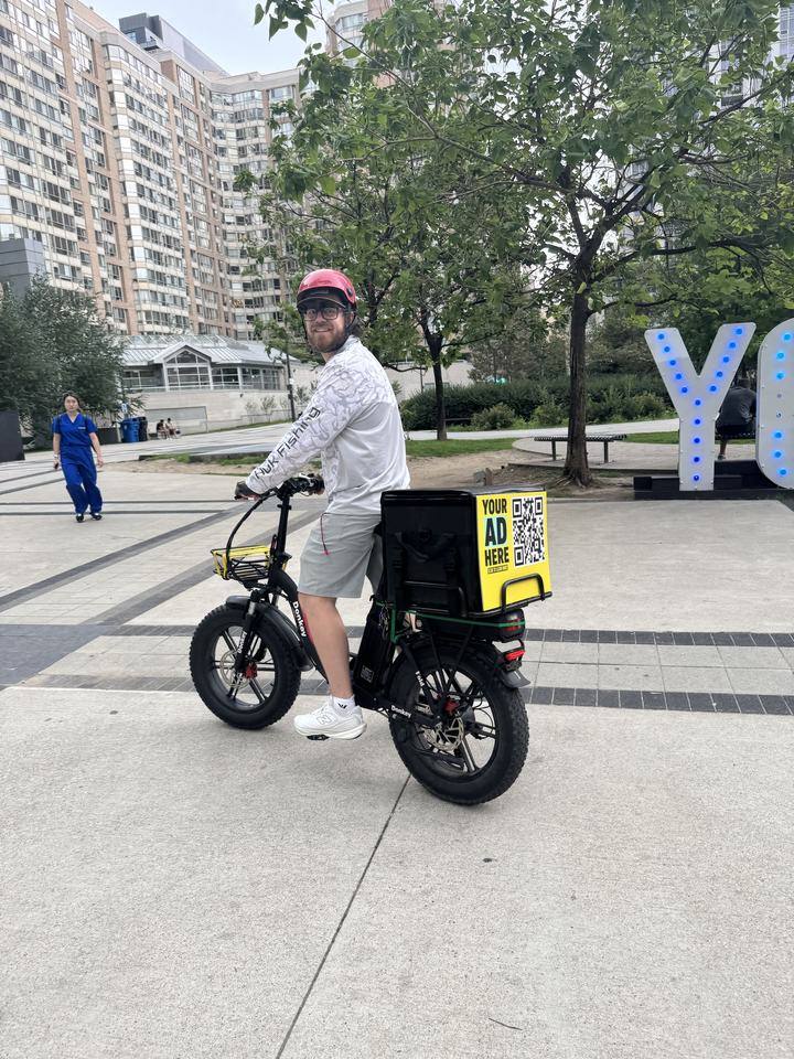 Our founder on his delivery e-bike with an ad panel